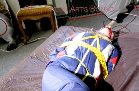 HOT HOT SANDRA is secured with ropes and covered with a cloth gag.