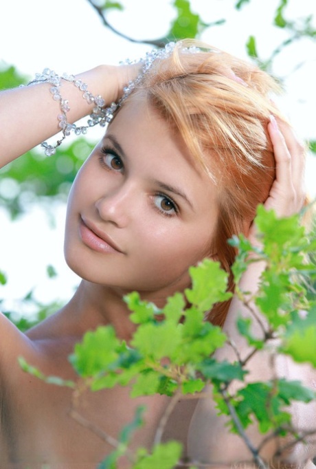 Adorable redhead Violla A displays her naked teen body atop a rock outdoors