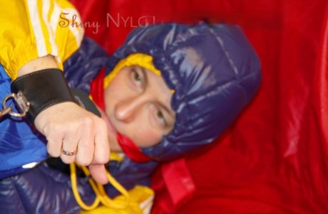 Sonja was confined to a bar, gagged, and hooded on a sofa while wearing suggestive rain gear.