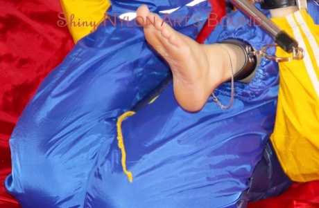 With a bar tied, gagged, and a hooded on the sofa, Sonja was seen wearing a sensual raincoat and paddling around.