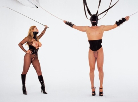 Swirling woman releases male slaves from suspension bondage before MMF sex.