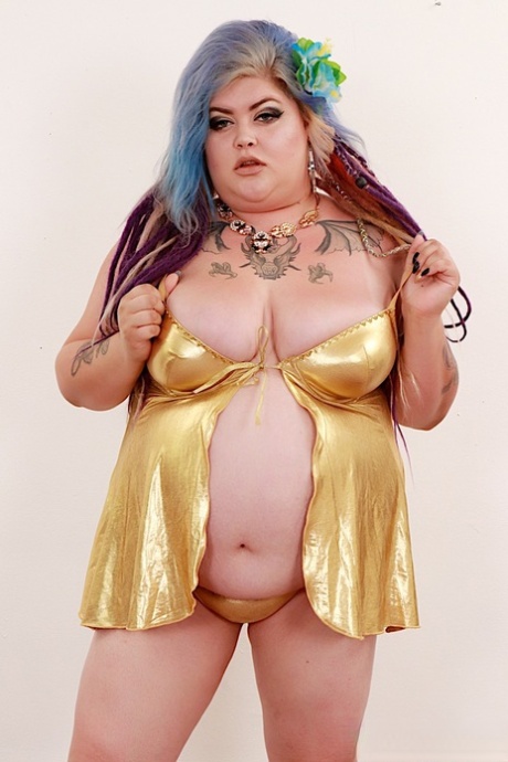 Obese Sasha Syren displays her pussy while wearing a flower in dyed hair.