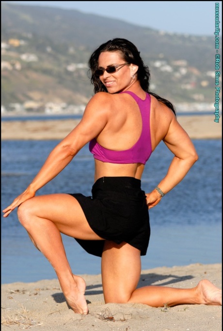 Brunette Bodybuilder Lada Phihalova Flexes On A Beach While Wearing Sunglasses