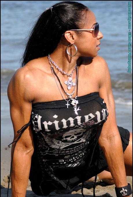 Ebony Bodybuilder Stacy Simons Flexes On A Beach While Wearing Sunglasses