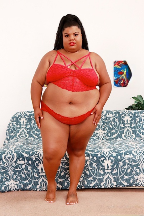 While getting naked, Ebony SSBBW Peaches Love displays red lips.