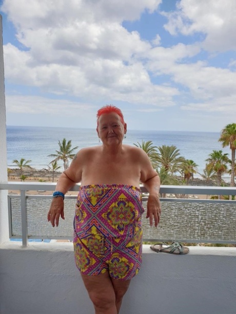 Before posing naked, the obsessive nan with spiky red hair exposes her pants on the balcony.