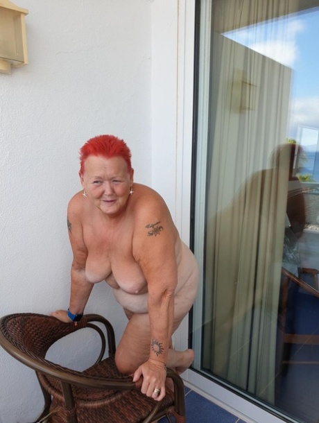 Before posing in the nude, the obsessian naked monkey with deep red hair exposes her pants on the balcony.