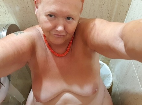 The chubby woman with red hair from Valgasmic Exposed takes nude photos at her home.