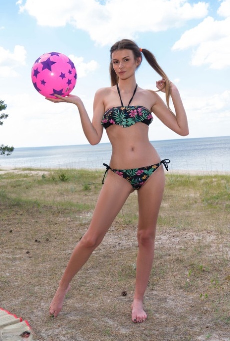 Tall teen Tora removes her bikini for nude poses in pigtails down by the water