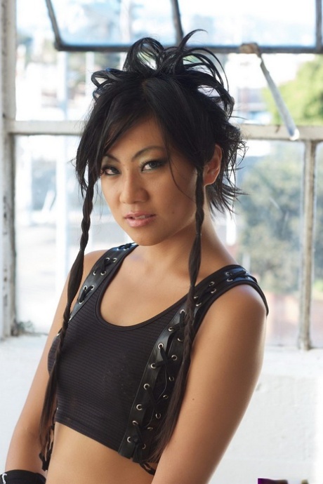 Wearing knee high boots and leather arm socks, an Asian alternative girl poses in the nude.