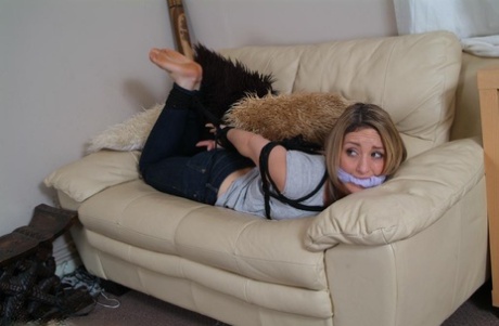 A revealing girl struggles on her loveseat, tightly wrapped and bound in her fingers.