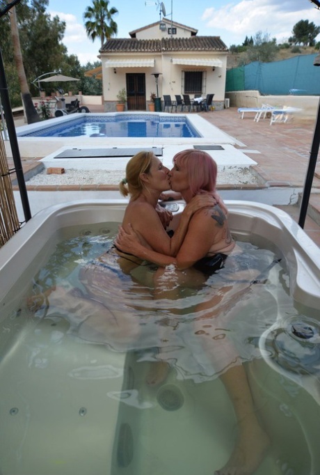 After kissing in a hot tub, mature lesbians with big bellies start to showered with pussy.