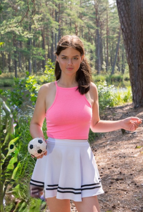 Di, a busty girl who is dressed in a short skirt, takes to the woods while being naked.