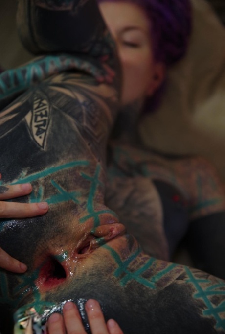 A girl who is extremely tattooed has her lover snoring in her anus.