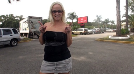 Dee Siren, a young girl with blonde hair, displays her big tits in public before interracial sex.