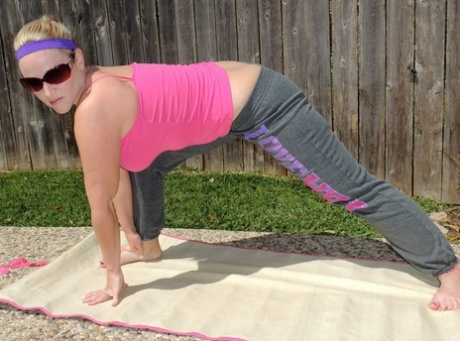 Barefoot amateur Dee Siren displays her large buttocks while practicing yoga near a pool.