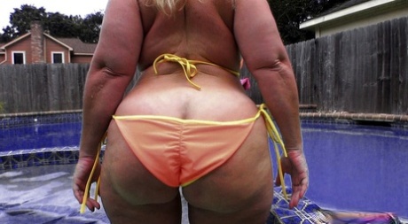 Amateur female Dee Siren flaunts her large buttocks while donning a string bikini.