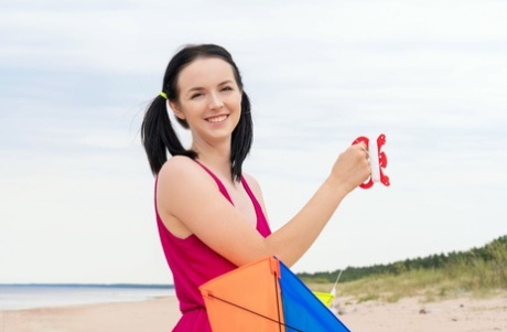 While flying a kite on a beach, young blonde Stacy exposes herself completely.