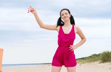 The young blonde Stacy goes kite surfing on a beach while being nude.