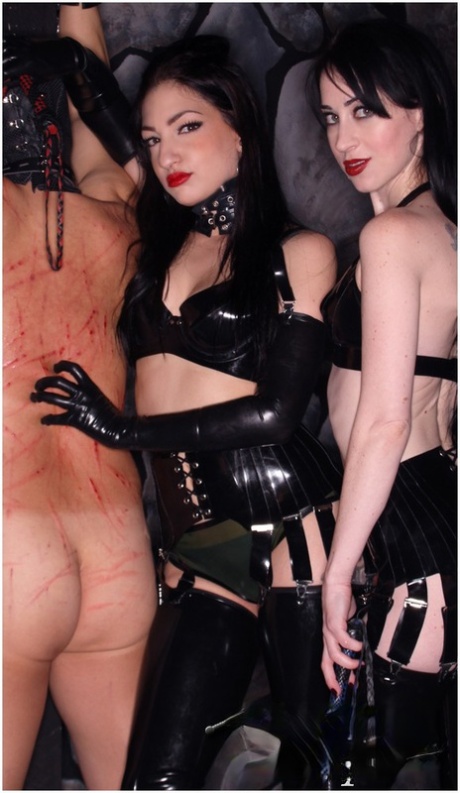 Scratch marks are left on the back of a male slave by Cybill Troy and Mina Meow.