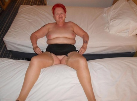 Fat redhead nan Valgasmic Exposed poses nude on a bed in tan nylons and heels - PornHugo.net