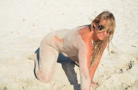 Wet and dirty: Naked star Sweet Susi hide herself in shades of the beach sand.