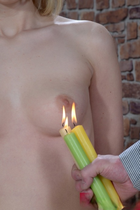 Hot candle wax is used to torture the skinny blonde slave before sexual intercourse.