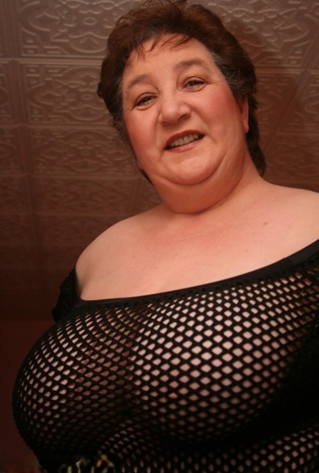 Thick Older Woman Kinky Carol Sports Short Hair While Modelling A Mesh Dress