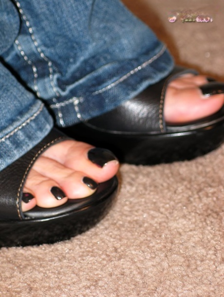 Любительская модель снимает каблуки с черными ногтями на ногах