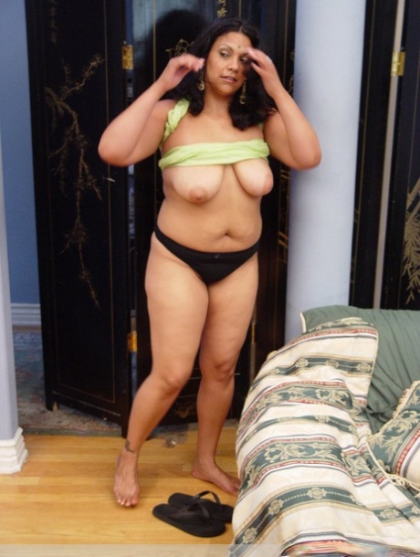 A stout Indian woman exposes her natural tits while wearing a black thong.