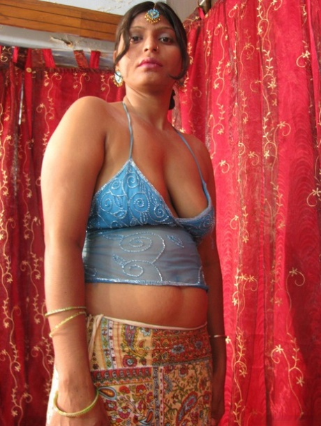 On a bed, a sluggish Indian woman displays her natural tits and shaved off body.