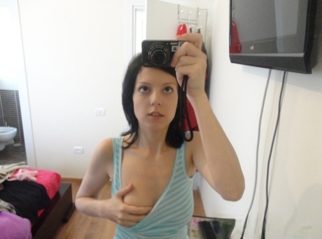 This photo features a young and brunette looking woman taking selfies while wearing white socks.