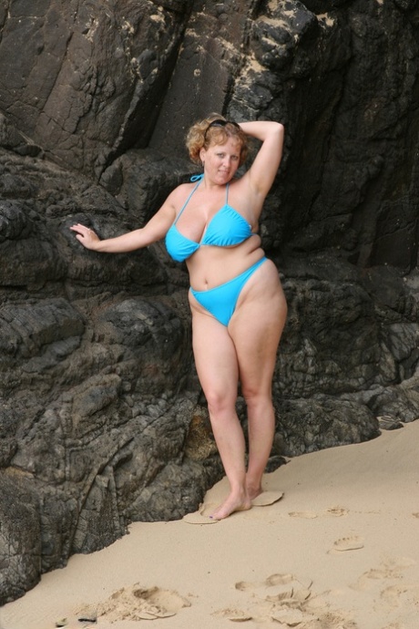 Curvy Claire, a thick British woman in her bikini by the sea, loosens her breasts.