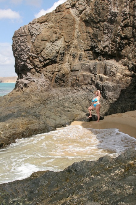 Bum spotting: British woman Curvy Claire loses her breast covering as she walks by the sea in a thick bikini.