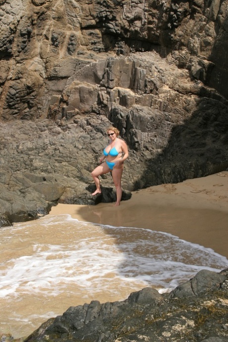 Claire, a curvy British woman with thick chestnut skinned legs, exposes her breasts while swimming in the sea.