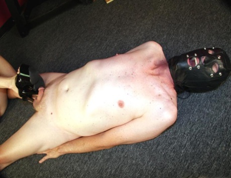 The dominant female offers a CBT session to a naked male slave.