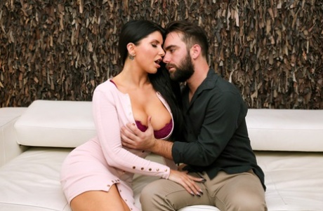 Busty brunette Romi Rain has sex with her man friend on a sofa