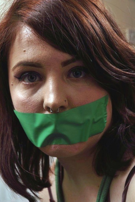 As the girl wears her clothes and is tied up, she lies in wait with a strip of tape covering her mouth.