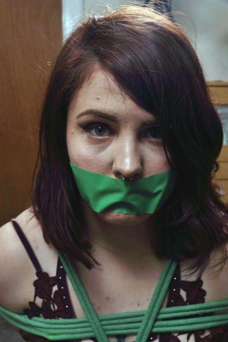 When the girl wearing clothes is tied up, she's restrained with a strip of tape covering her mouth and keeping quiet.