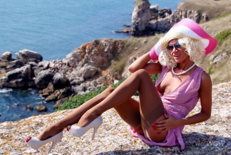 Blonde MILF Goes Topless On A Seaside Cliff In A Big Hat And Nylons Plus Heels