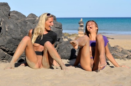 Two Girls Expose Their Underboobs And Shaved Pussies On A Sandy Beach