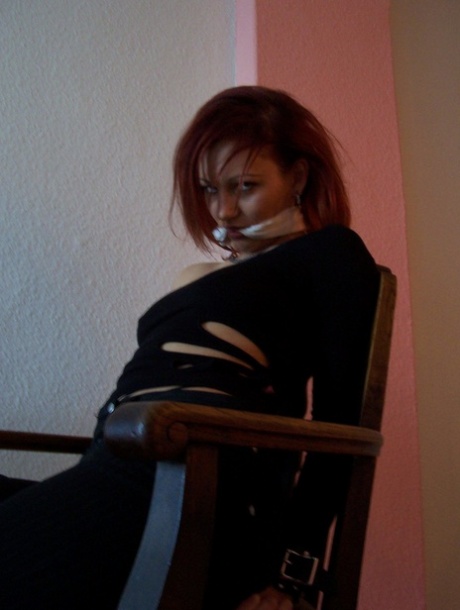 Wearing his cleave gag, Lilu, the white-haired redhead, is fully clothed.