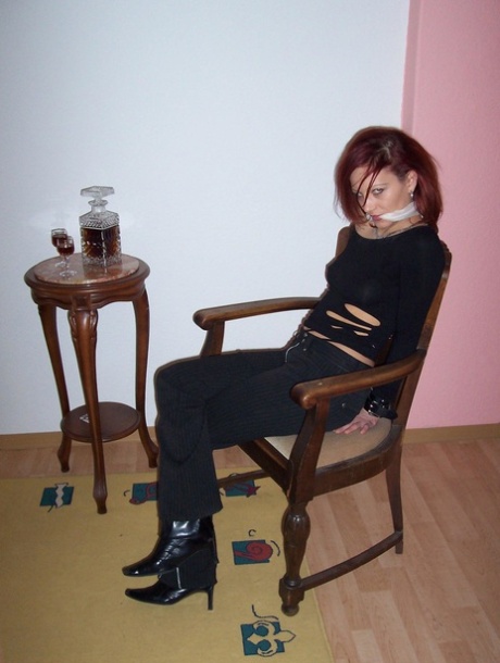 Wearing his cleave gag, Lilu, the white-haired redhead, is fully clothed.