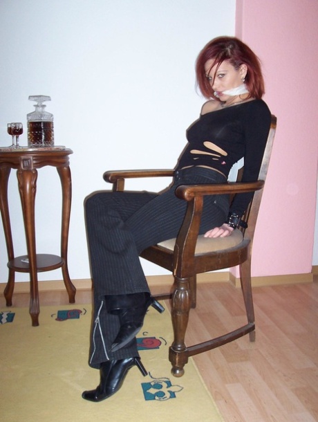 Wearing his cleave gag, Lilu, the white-haired redhead, is fully clothed.