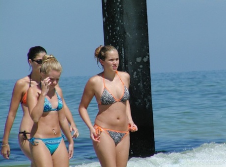 Secretly filmed: Young girls in bikinis wade into the ocean below.