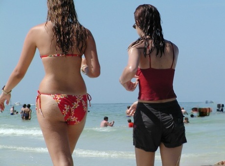 The ocean is secretly being watched as young girls wade through it in their bikinis.