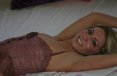 Blonde, dirty-haired models naked in sensual lingerie on her bed.