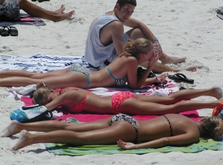 At the seaside, hot girls are seen sporting tight bikinis while enjoying the beach.