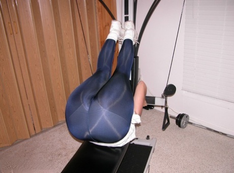 When she is a mature amateur, Devlynn exposes her stomach and takes hold of the home gym equipment.