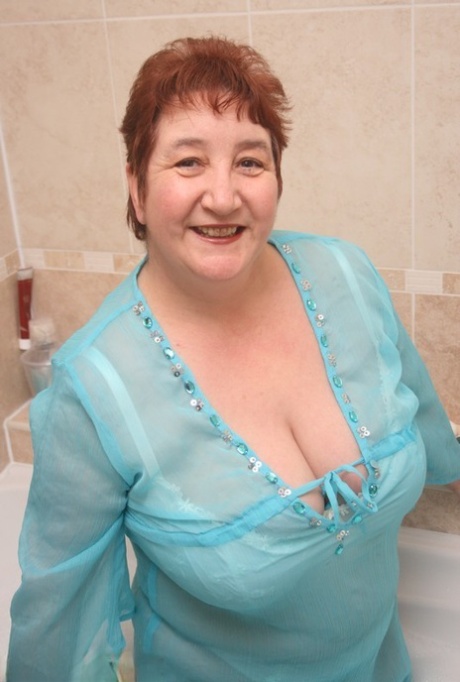 Full of clothes, redhead nan Kinky Carol enjoys her tub time.